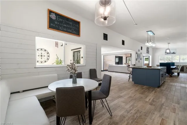 a living room with furniture kitchen view and a chandelier
