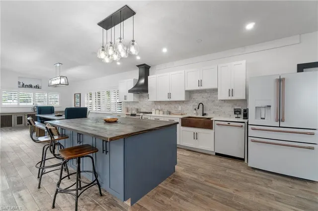 a kitchen with stainless steel appliances a table chairs and a chandelier