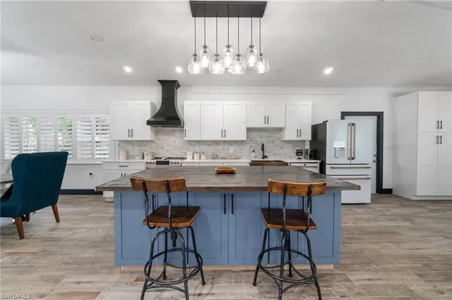 a kitchen with stainless steel appliances a dining table chairs and stove top oven