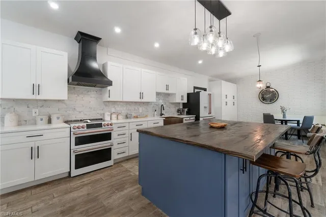 a kitchen with a stove a sink a dining table and chairs