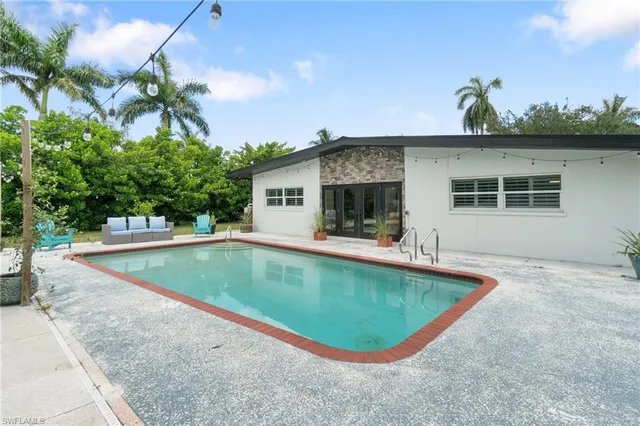 a view of swimming pool with outdoor seating and plants