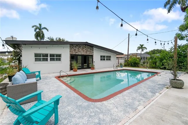 a swimming pool with outdoor seating and yard