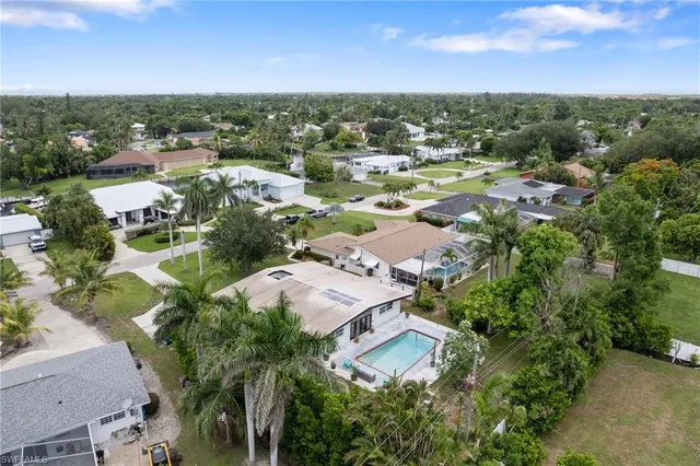 an aerial view of a city with lots of residential buildings ocean and mountain view in back