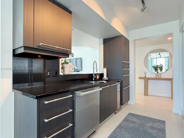 a kitchen with stainless steel appliances granite countertop a sink and a stove