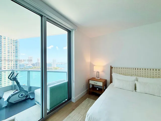 a bedroom with a bed and a large window