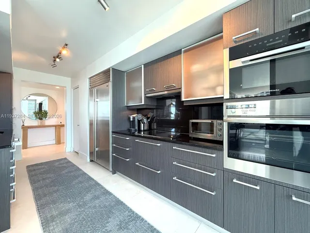 a kitchen with stainless steel appliances granite countertop a refrigerator and a stove top oven