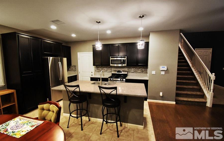 1955 Hope Valley Drive Reno, NV 89521 - Photo 4 of 16 a kitchen with stainless steel appliances kitchen island granite countertop a refrigerator a stove a microwave oven a sink with island and chairs