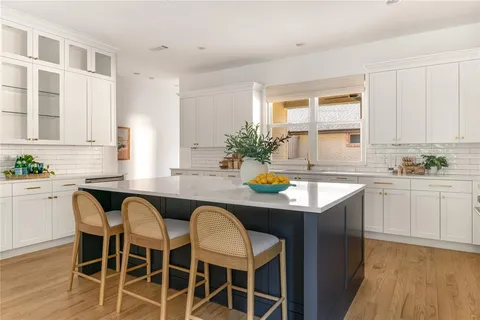 a kitchen with stainless steel appliances granite countertop a table chairs stove a sink and dishwasher with wooden floor