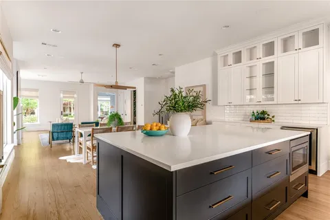 a kitchen with a table chairs and white cabinets