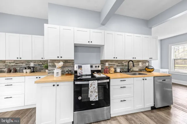 a kitchen with granite countertop white cabinets and white appliances
