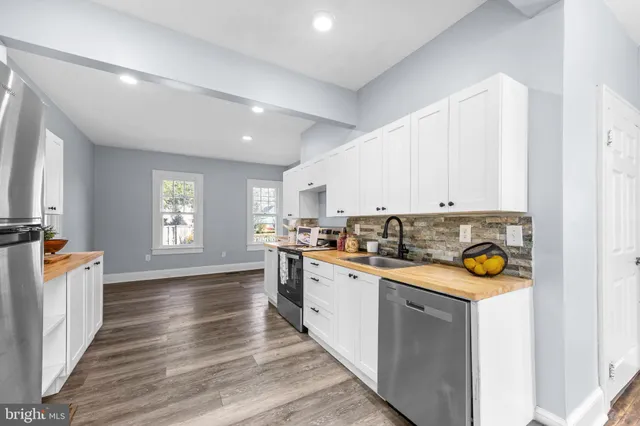 a kitchen with a sink a stove cabinets and counter space