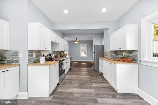 a large kitchen with kitchen island sink and cabinets