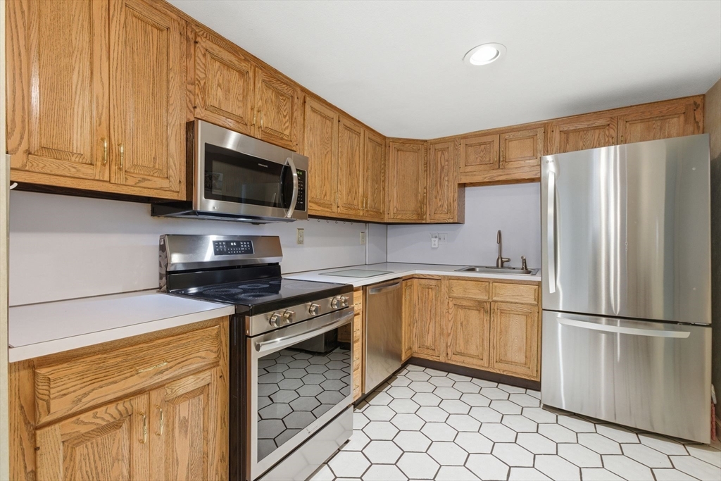 3 Spruce Street Stoneham, MA 02180 - Photo 16 of 38 a kitchen with stainless steel appliances granite countertop a refrigerator stove top oven and sink