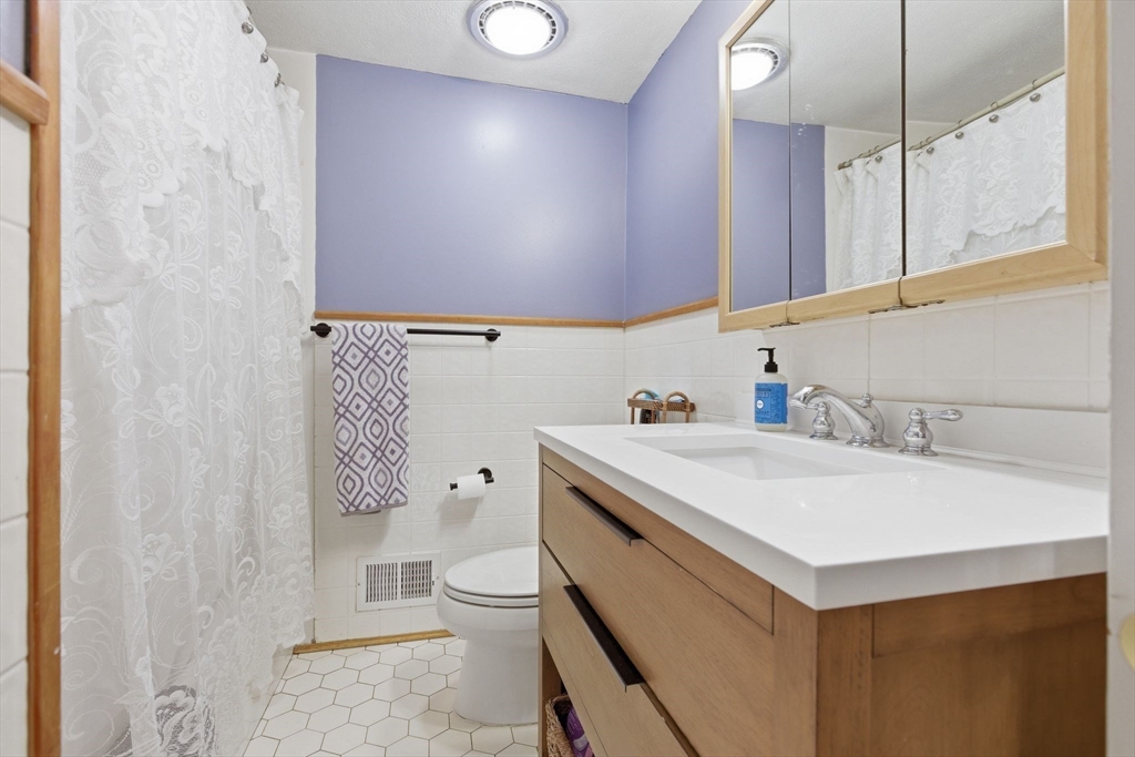 3 Spruce Street Stoneham, MA 02180 - Photo 22 of 38 a bathroom with a sink a toilet and mirror