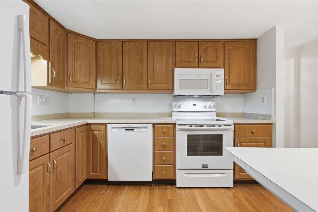 3 Spruce Street Stoneham, MA 02180 - Photo 3 of 38 a kitchen with cabinets appliances and a wooden floor