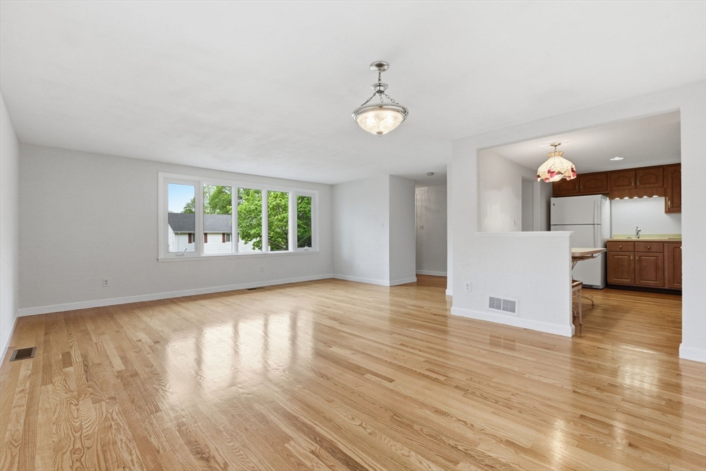 3 Spruce Street Stoneham, MA 02180 - Photo 6 of 38 an empty room with wooden floor and windows