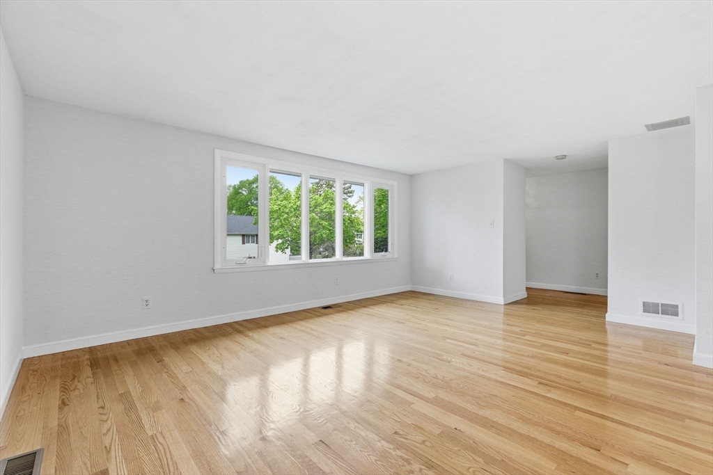 3 Spruce Street Stoneham, MA 02180 - Photo 7 of 38 an empty room with wooden floor and windows