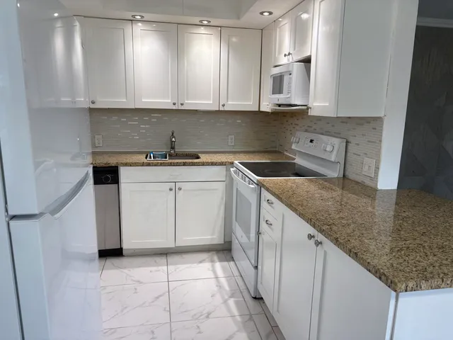 a kitchen with stainless steel appliances granite countertop a sink stove and cabinets