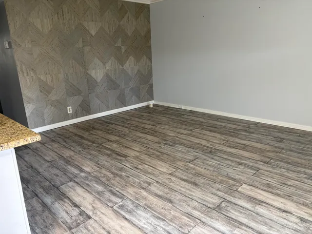 a view of an empty room with wooden floor