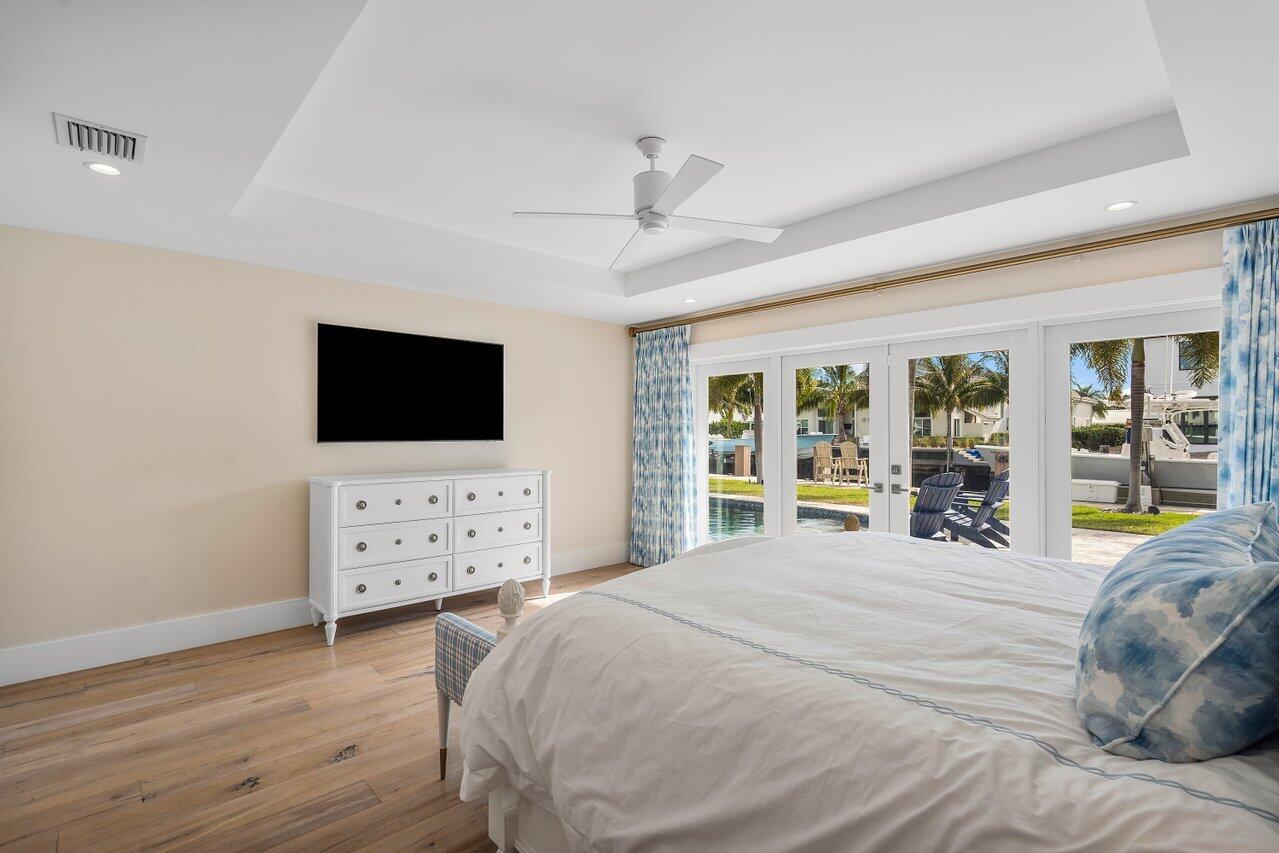 1041 Gulfstream Way Singer Island, FL 33404 - Photo 16 of 41 a large bedroom with a bed and a flat tv screen on dresser