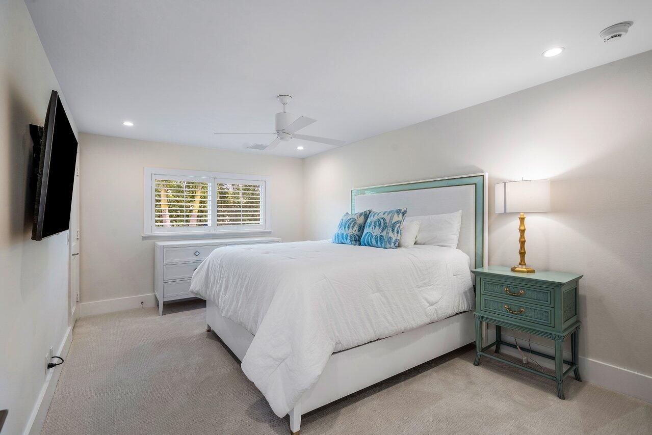 1041 Gulfstream Way Singer Island, FL 33404 - Photo 20 of 41 a spacious bedroom with a bed a mirror on dresser and a wooden floor