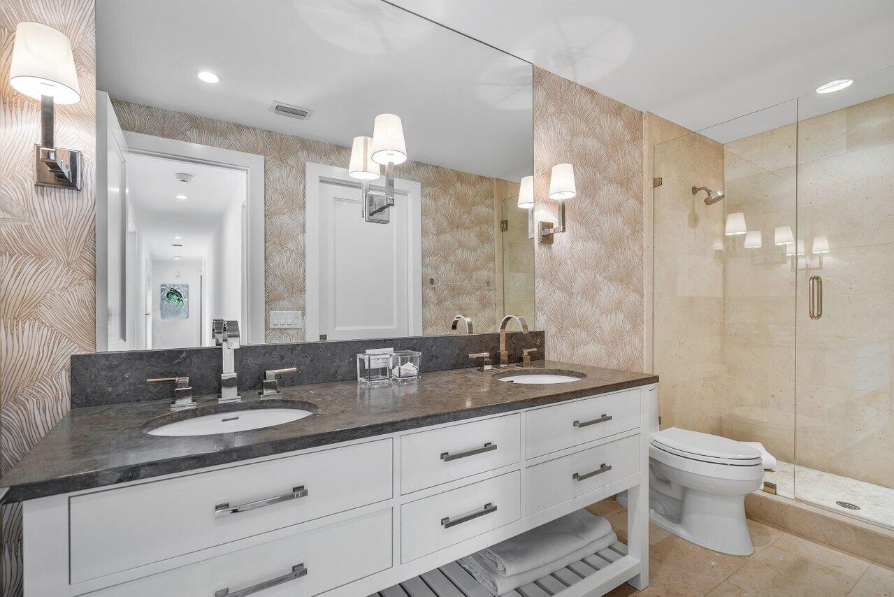 1041 Gulfstream Way Singer Island, FL 33404 - Photo 21 of 41 a bathroom with a granite countertop double vanity sink a mirror a toilet and a shower