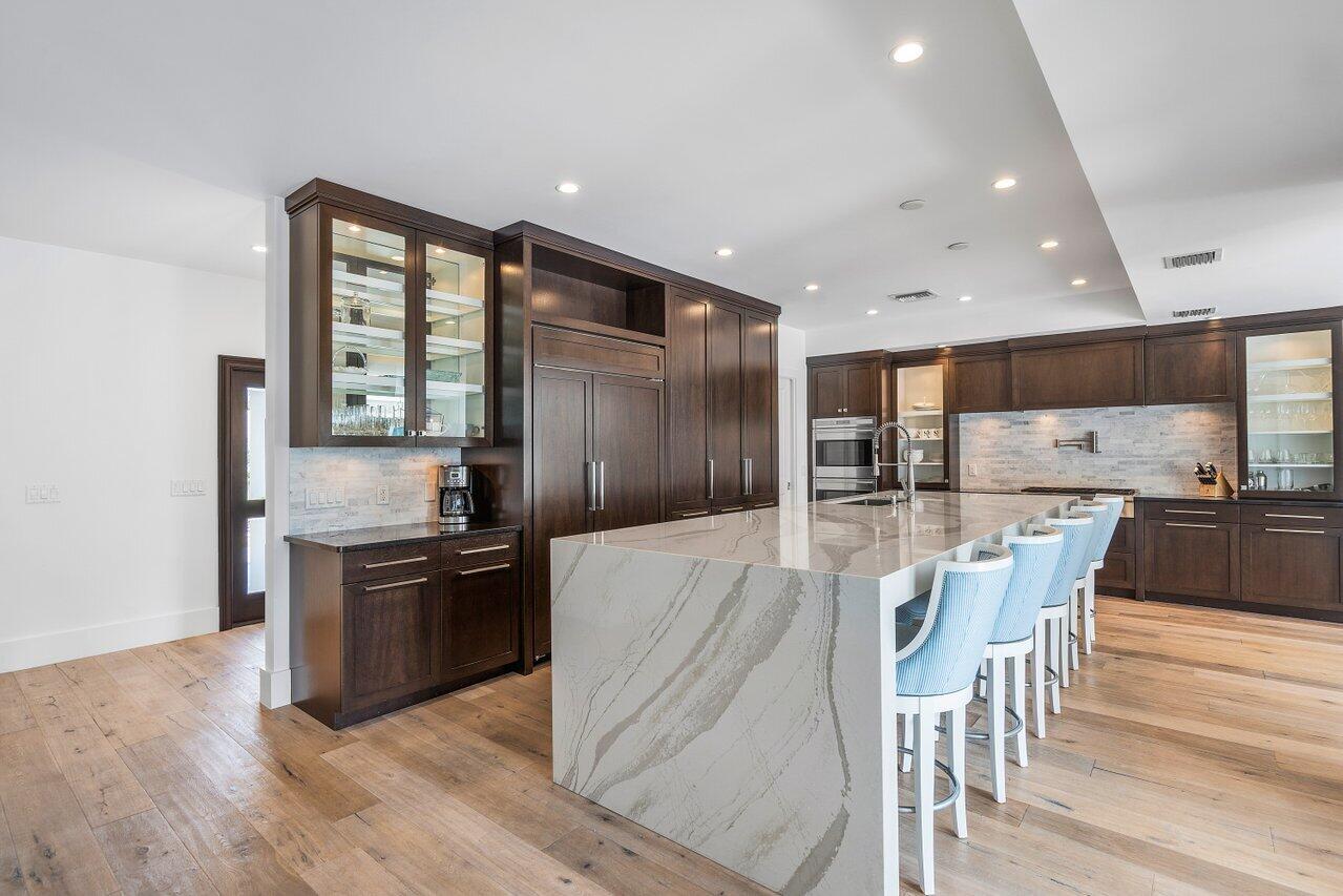 1041 Gulfstream Way Singer Island, FL 33404 - Photo 10 of 41 a kitchen with stainless steel appliances granite countertop wooden floor a refrigerator and a stove
