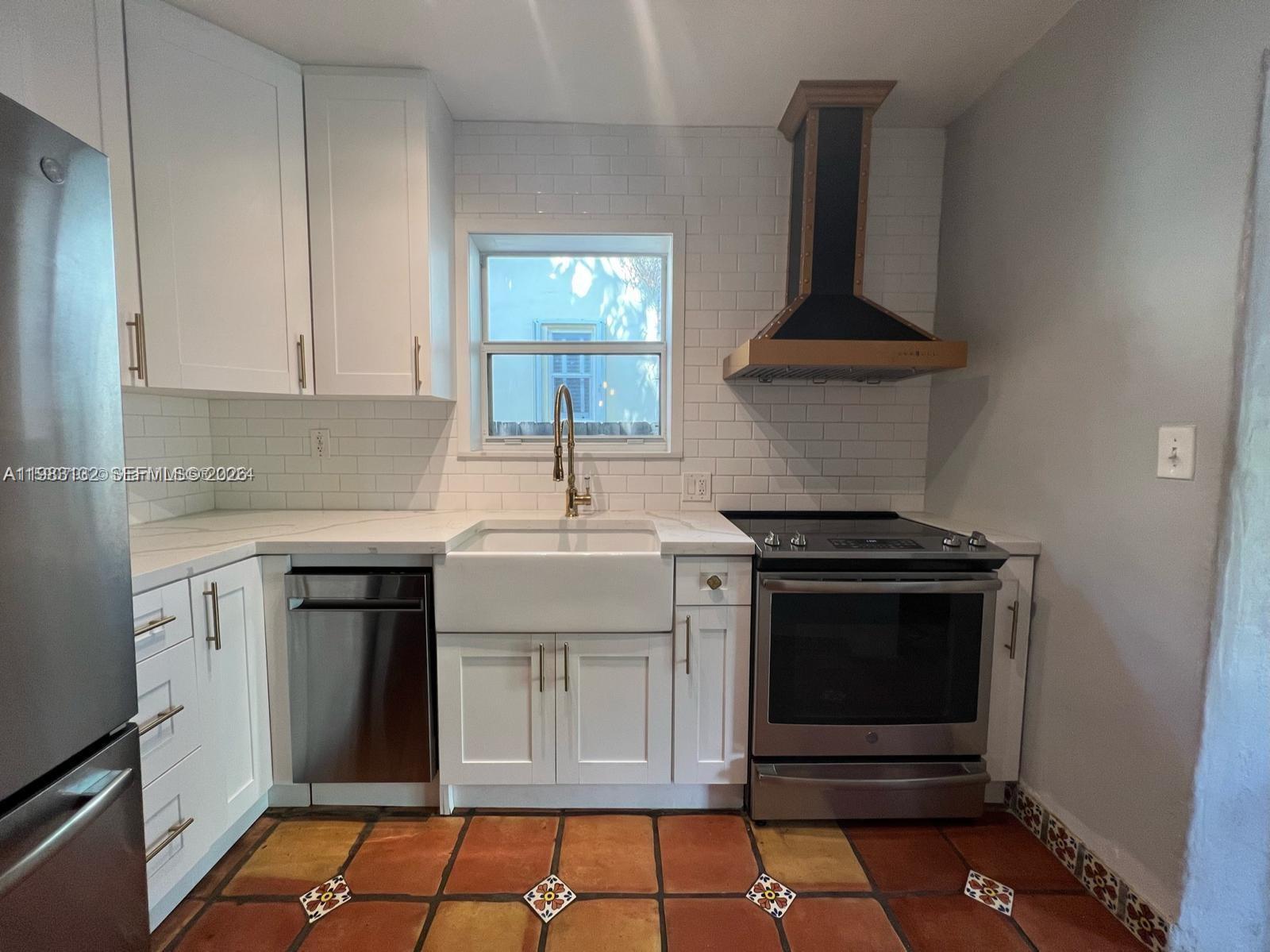 551 Northeast 69th Street, Unit 1&2 Miami, FL 33138 - Photo 5 of 15 a kitchen with stainless steel appliances a stove and white cabinets