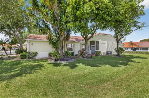 a front view of a house with a garden and yard