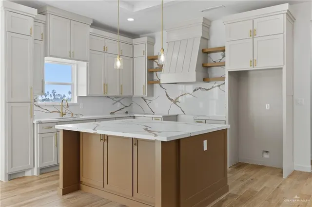a kitchen with kitchen island granite countertop a sink and cabinets