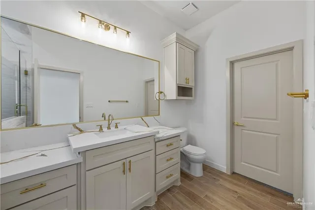 a bathroom with a sink a toilet and a mirror