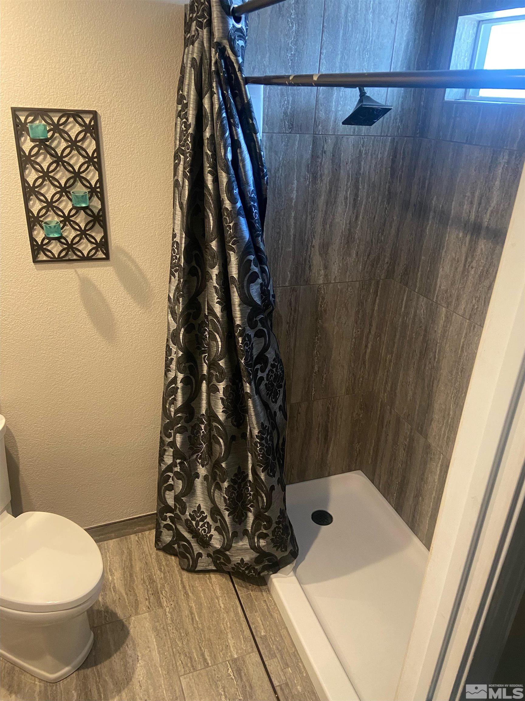 860 Swaledale Drive Reno, NV 89511 - Photo 16 of 19 a bathroom with a toilet and shower curtain