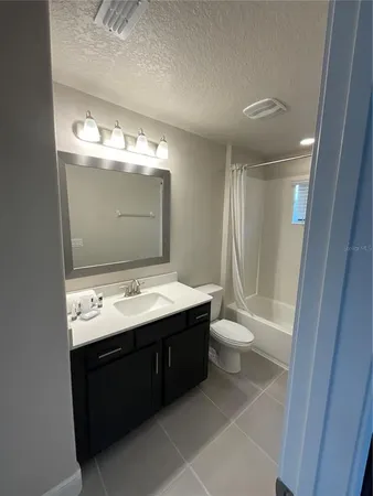a bathroom with a sink a toilet a mirror and shower