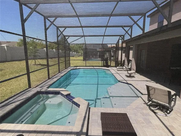 a view of house with backyard and outdoor seating