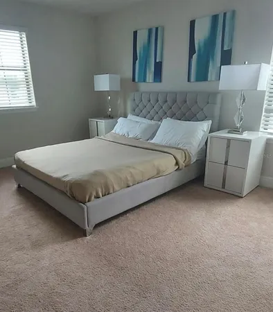 a bedroom with a bed and painting on the wall