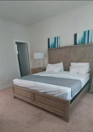 a bed room with a bed a couch and a flat screen tv