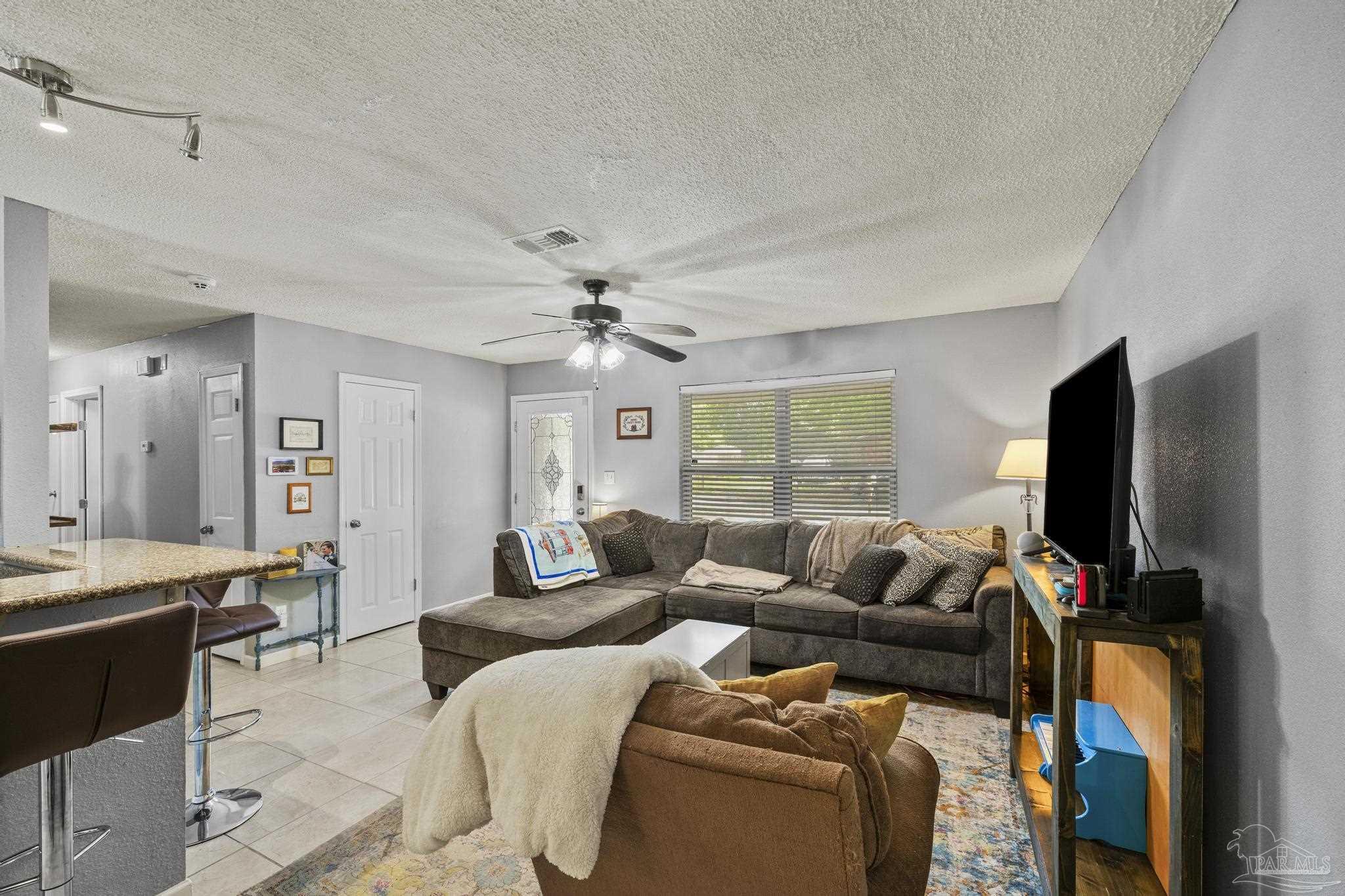 4281 Tomahawk Trail Milton, FL 32583 - Photo 15 of 42 a living room with furniture a ceiling fan and a flat screen tv