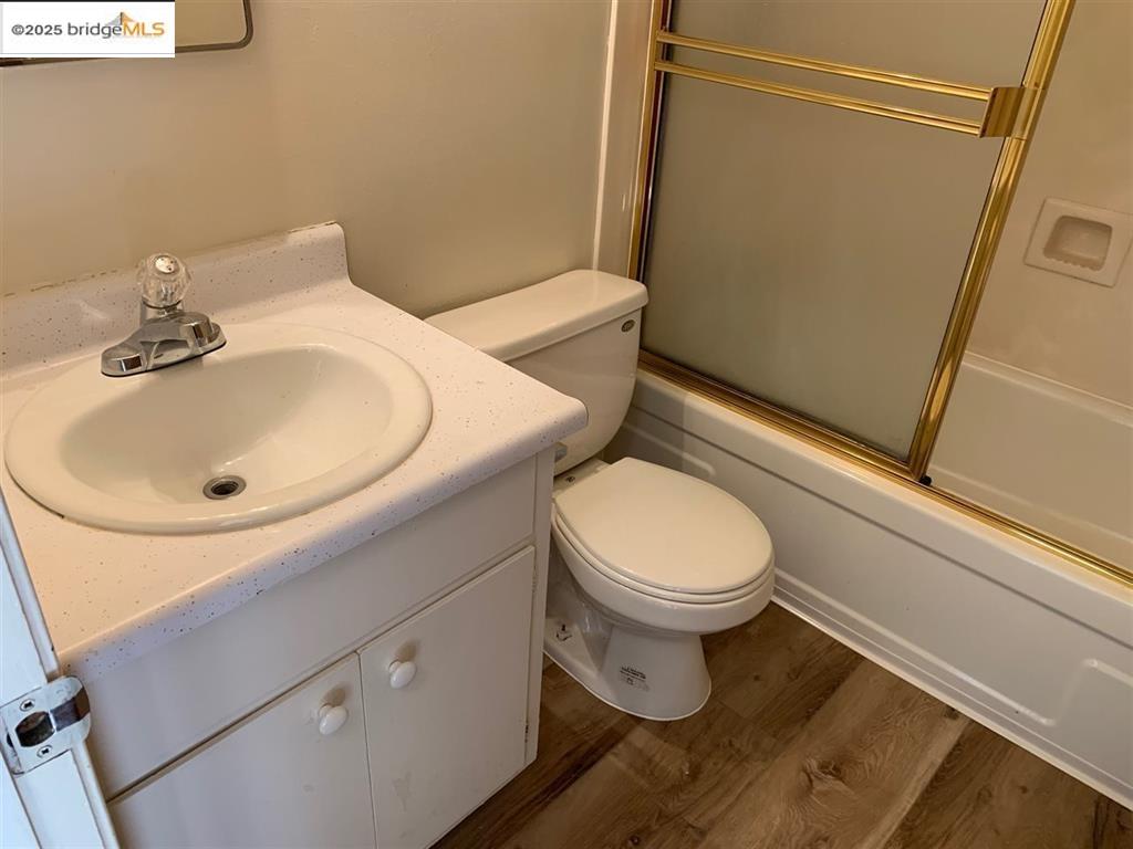 708 Solano Avenue, Unit D Albany, CA 94706 - Photo 20 of 23 Full bath featuring vanity, shower / bath combination with glass door, and dark wood-style floors