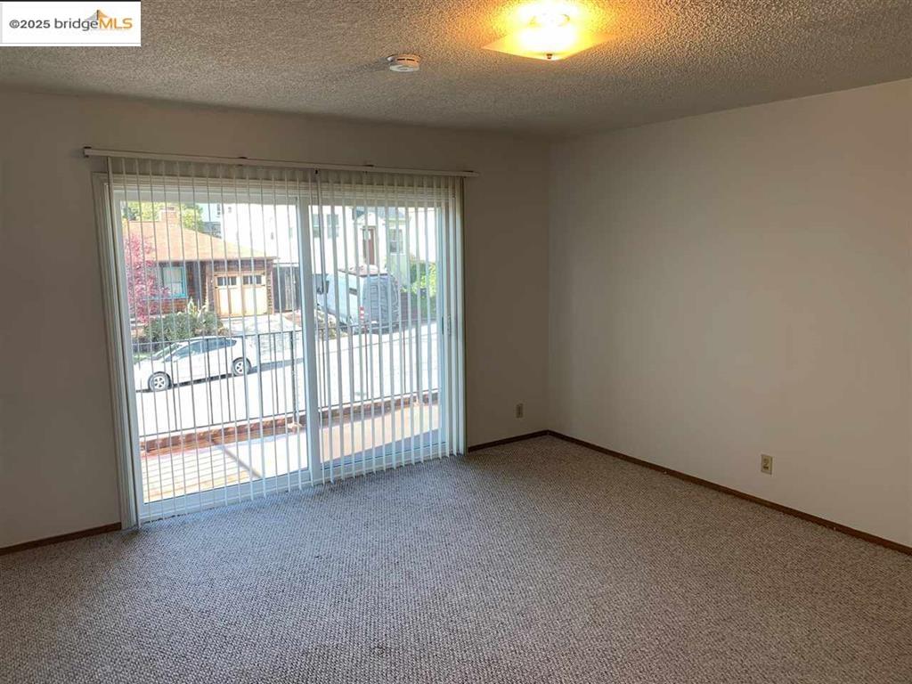 708 Solano Avenue, Unit D Albany, CA 94706 - Photo 10 of 23 Spare room with a textured ceiling, healthy amount of natural light, and light carpet