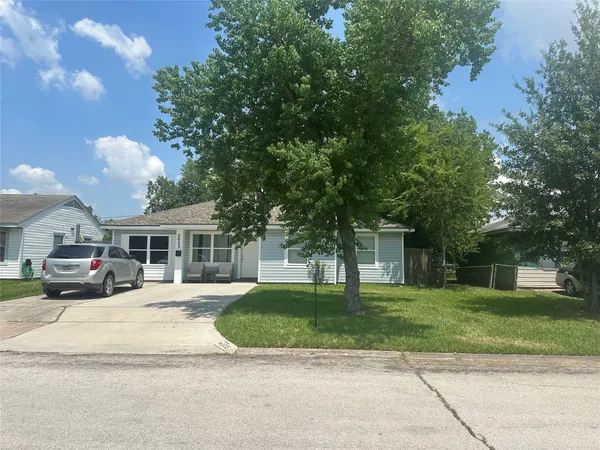 a front view of a house with a yard and potted plants