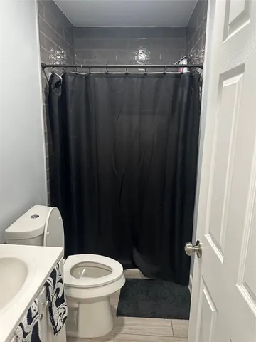 a bathroom with a shower a toilet and sink