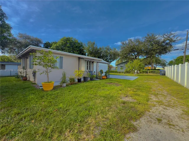 a view of a house with backyard and a tree