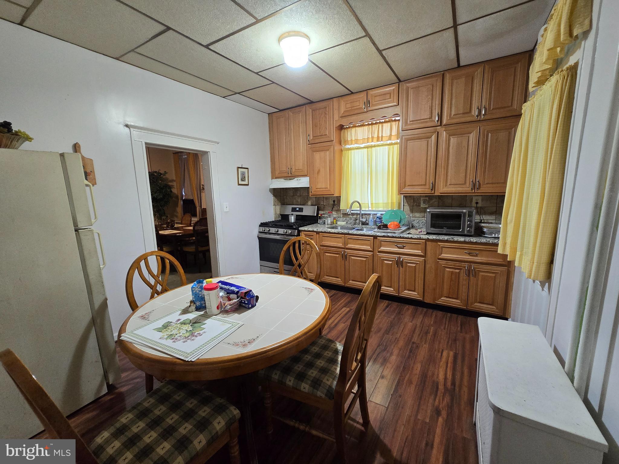 5533 Gwynn Oak Baltimore, MD 21207 - Photo 13 of 44 a kitchen with stainless steel appliances granite countertop a sink a stove a refrigerator a dining table and chairs