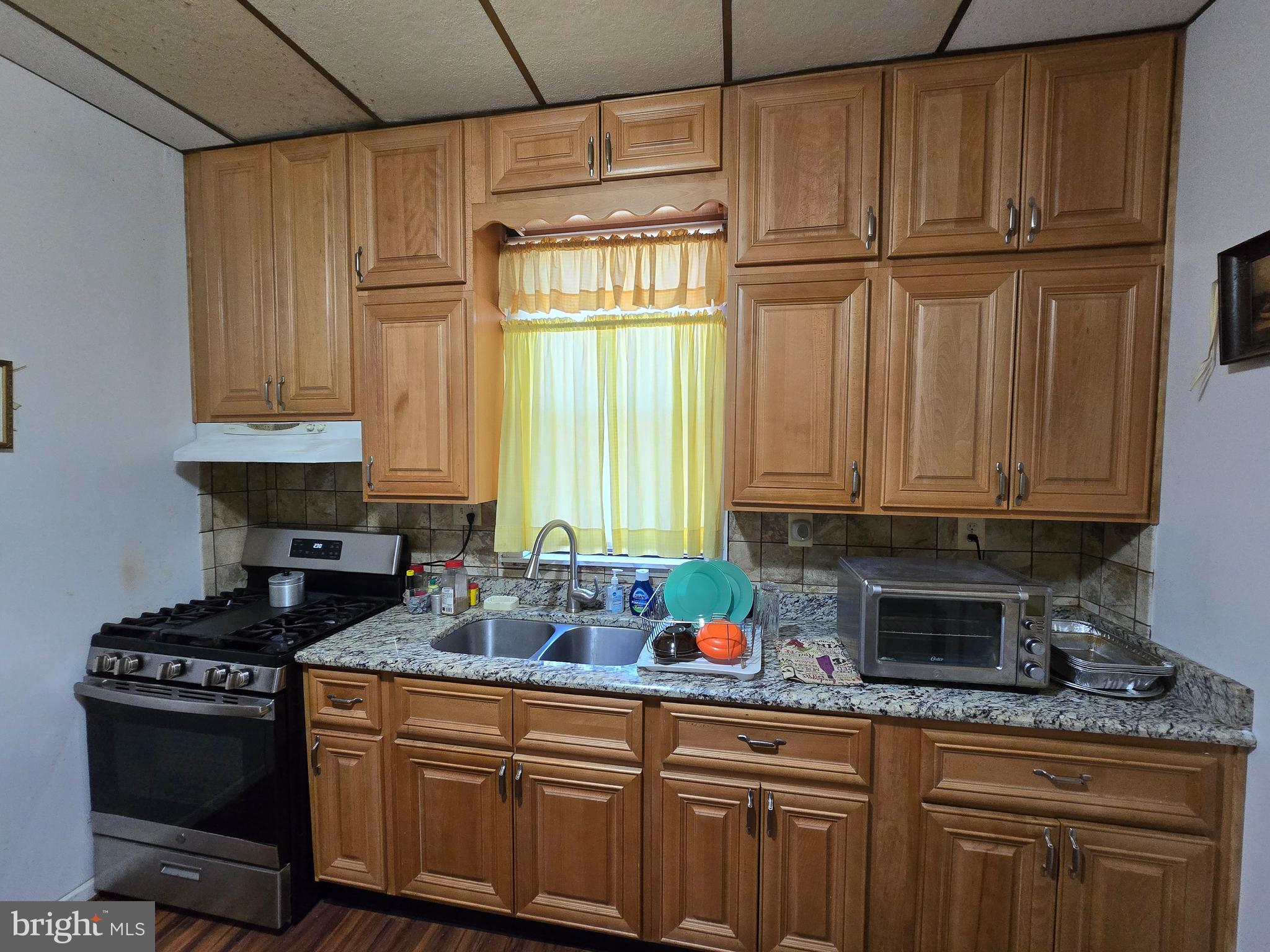 5533 Gwynn Oak Baltimore, MD 21207 - Photo 14 of 44 a kitchen with stainless steel appliances granite countertop a refrigerator stove and sink