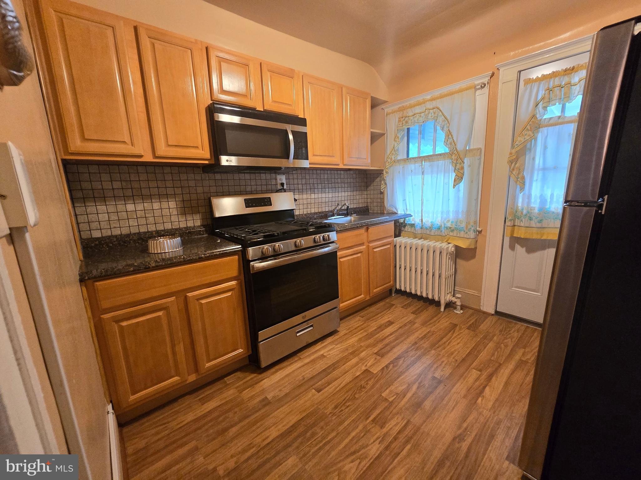 5533 Gwynn Oak Baltimore, MD 21207 - Photo 41 of 44 a kitchen with stainless steel appliances granite countertop a stove a sink and a microwave