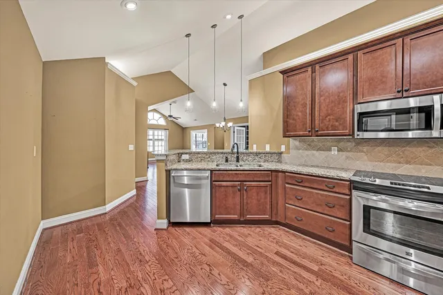 a kitchen with stainless steel appliances granite countertop a stove a sink and a microwave