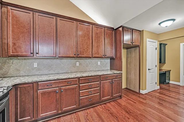 a view of a kitchen with wooden floor and cabinets