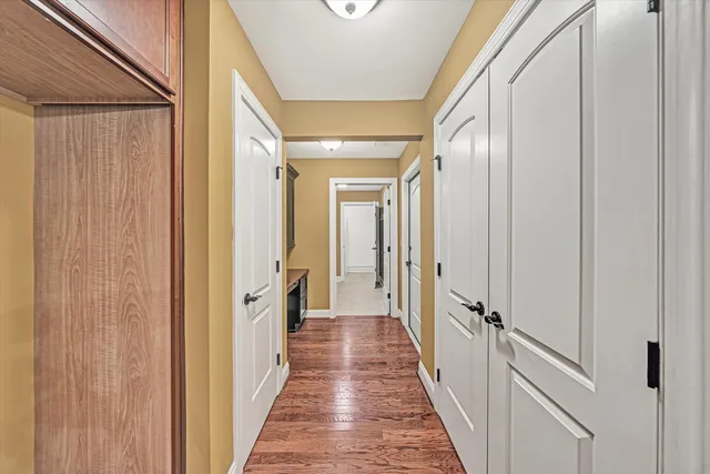 a view of a hallway with a door and wooden floor