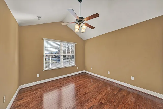 a view of a big room with wooden floor and a ceiling fan