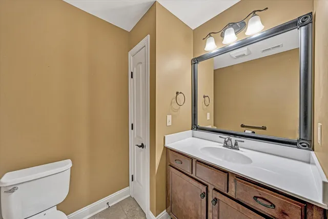 a bathroom with a sink a toilet and mirror